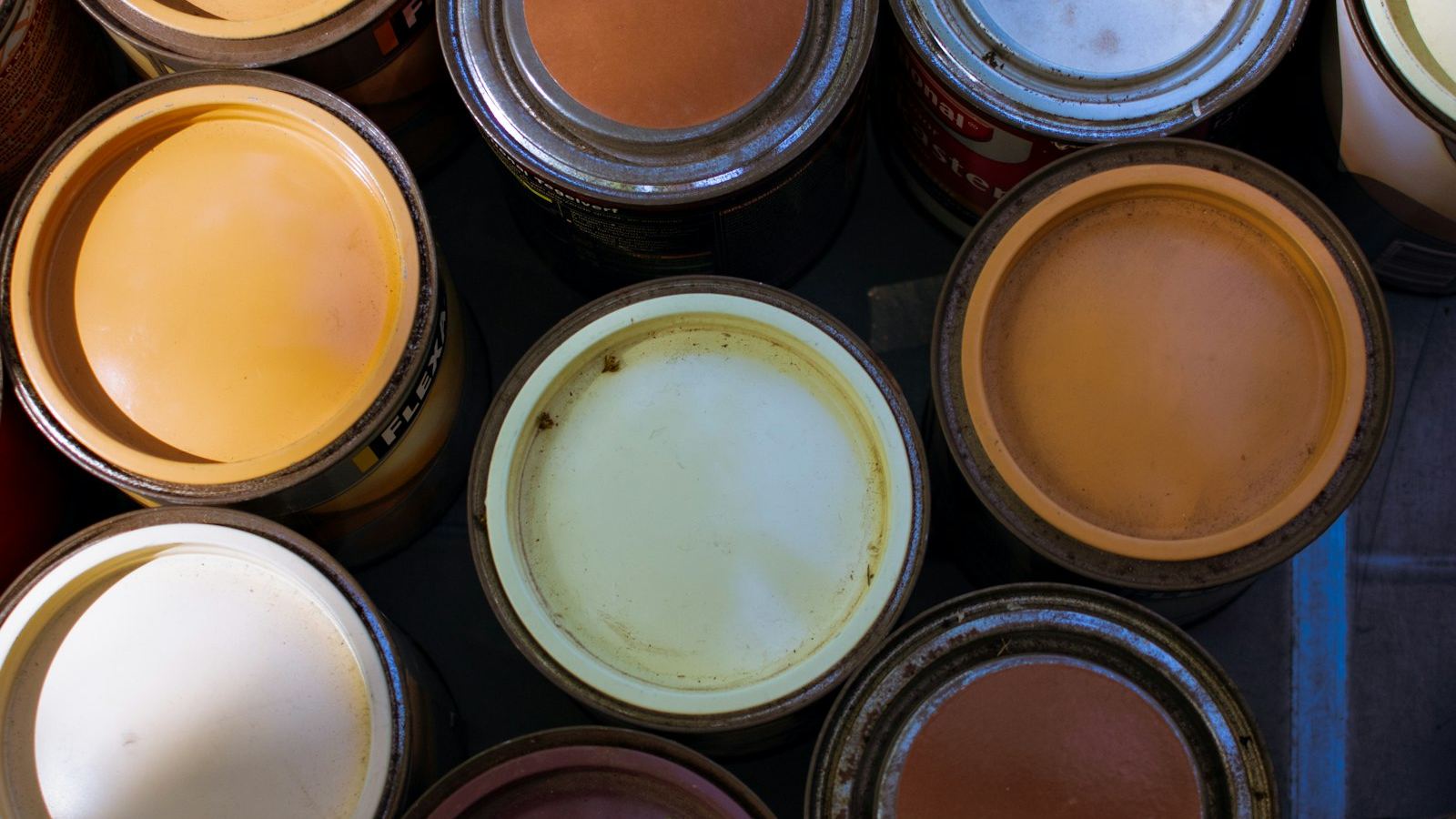 Open cans of paint in warm and neutral colors